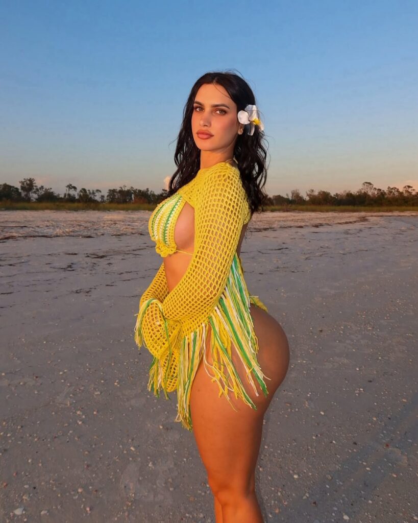 Violet Moore in a yellow dress by the water