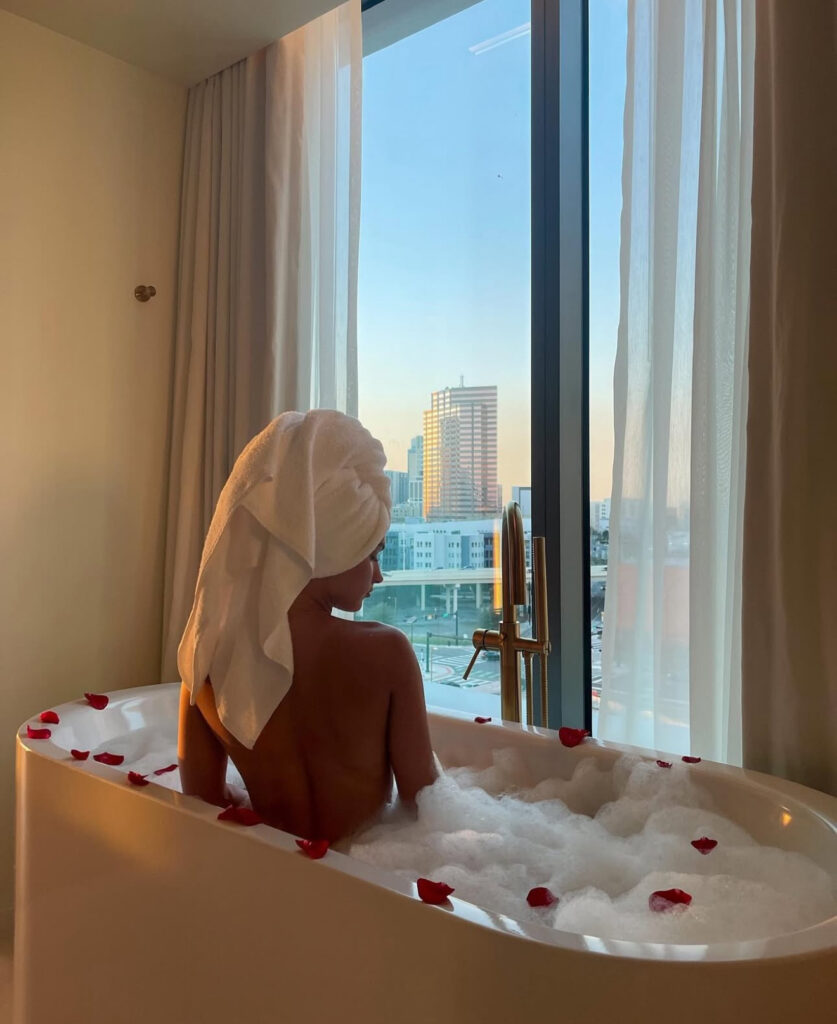 Violet Moore in a bath beside a city view